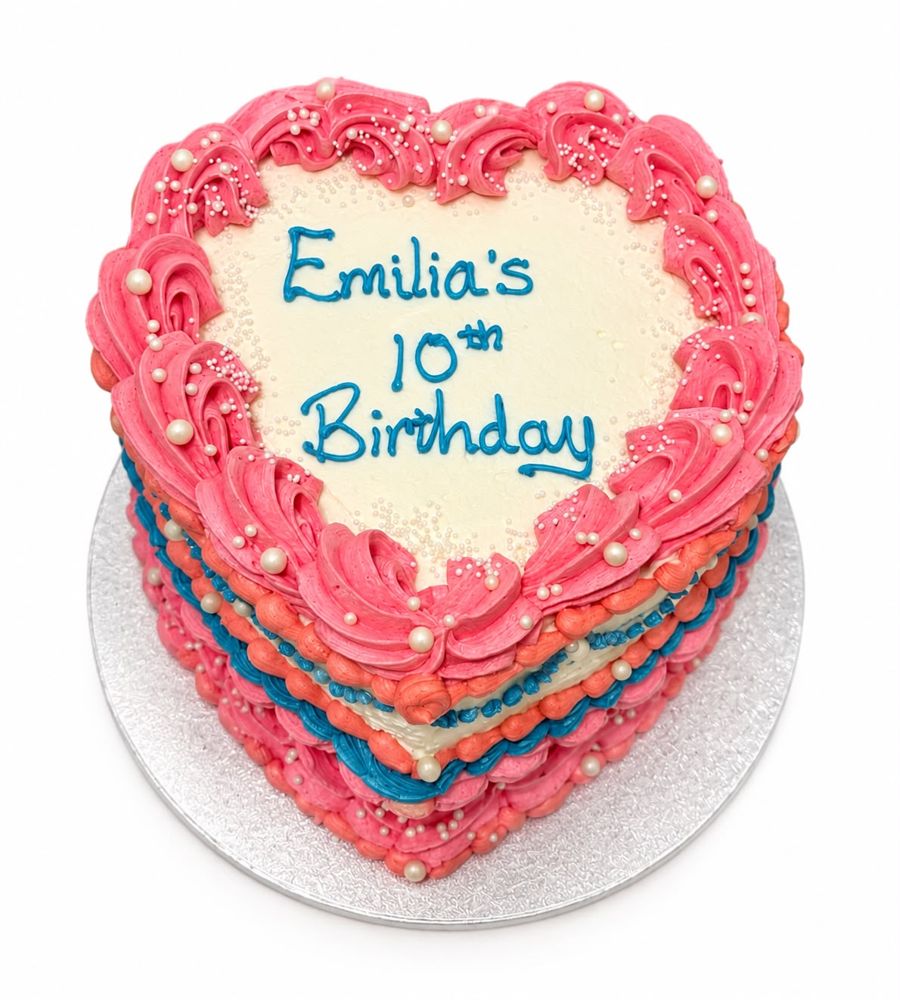 Heart-shaped pink Lambeth piped birthday cake